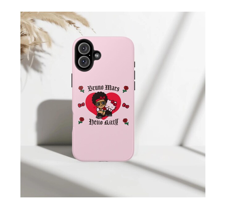 Puede incluir: Funda de tel&eacute;fono rosa claro con un gr&aacute;fico de dibujos animados de Bruno Mars y Hello Kitty. El dise&ntilde;o incluye un coraz&oacute;n rojo, rosas y el texto "Bruno Mars" y "Hello Kitty" en una fuente decorativa. La funda tiene un recorte para c&aacute;mara de doble lente.