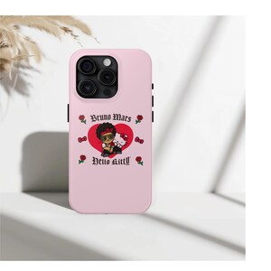Puede incluir: Funda de tel&eacute;fono rosa claro con un dise&ntilde;o de Bruno Mars y Hello Kitty. El dise&ntilde;o incluye un coraz&oacute;n rojo, rosas y los textos "Bruno Mars" y "Hello Kitty". La funda tiene un recorte para la c&aacute;mara y detalles negros.