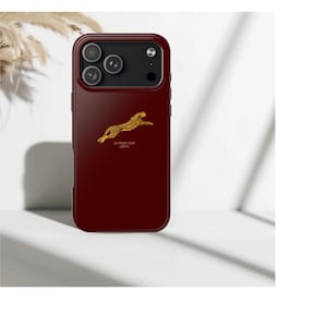 May include: A deep burgundy smartphone case featuring a gold-colored graphic of a leaping cheetah. Below the cheetah, the text reads "OUTRUN YOUR LIMITS" in small gold lettering. The case has a black camera module cutout with three circular lenses.