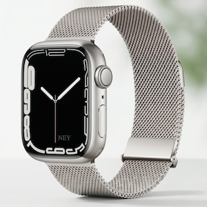 Może przedstawiać: Srebrny smartwatch z siatkowym paskiem. Tarcza zegarka jest czarna z białymi cyframi i wskazówkami, wskazującymi godzinę. Pasek wykonany jest z drobnego, tkanego metalu, a koperta zegarka ma gładką, odblaskową powierzchnię. Widoczny jest tekst "NEY".