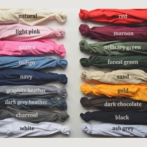 Puede incluir: Una carta de colores que muestra muestras de tela en una variedad de tonos. Las muestras est&aacute;n etiquetadas con nombres de colores como "natural", "rosa claro", "rojo" y "negro". La tela est&aacute; anudada al final de cada muestra.