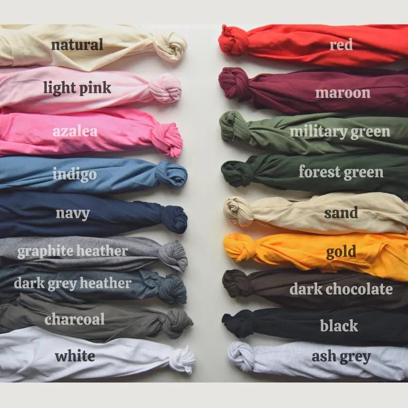 Puede incluir: Una carta de colores que muestra muestras de tela en una variedad de tonos. Las muestras est&aacute;n etiquetadas con nombres de colores como "natural", "rosa claro", "rojo" y "negro". La tela est&aacute; anudada al final de cada muestra.