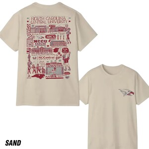 Puede incluir: Dos camisetas color arena. Una camiseta presenta un gr&aacute;fico granate de la Universidad Central de Carolina del Norte con texto. La otra camiseta tiene un logotipo de &aacute;guila granate en el pecho. La palabra "SAND" est&aacute; en la parte inferior.