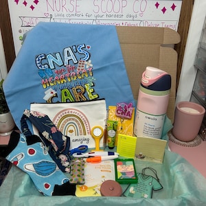 Peut inclure: Un coffret cadeau contenant un tissu bleu clair avec le texte CNA'S ARE THE HEARTBEAT OF LONG TERM CARE, une pochette blanche avec un arc-en-ciel, une gourde Owala rose et verte, des chaussettes &agrave; motifs, un bandeau floral, une horloge jaune, des stylos, des notes adh&eacute;sives, un masque pour les yeux et un ornement en forme de blouse verte.