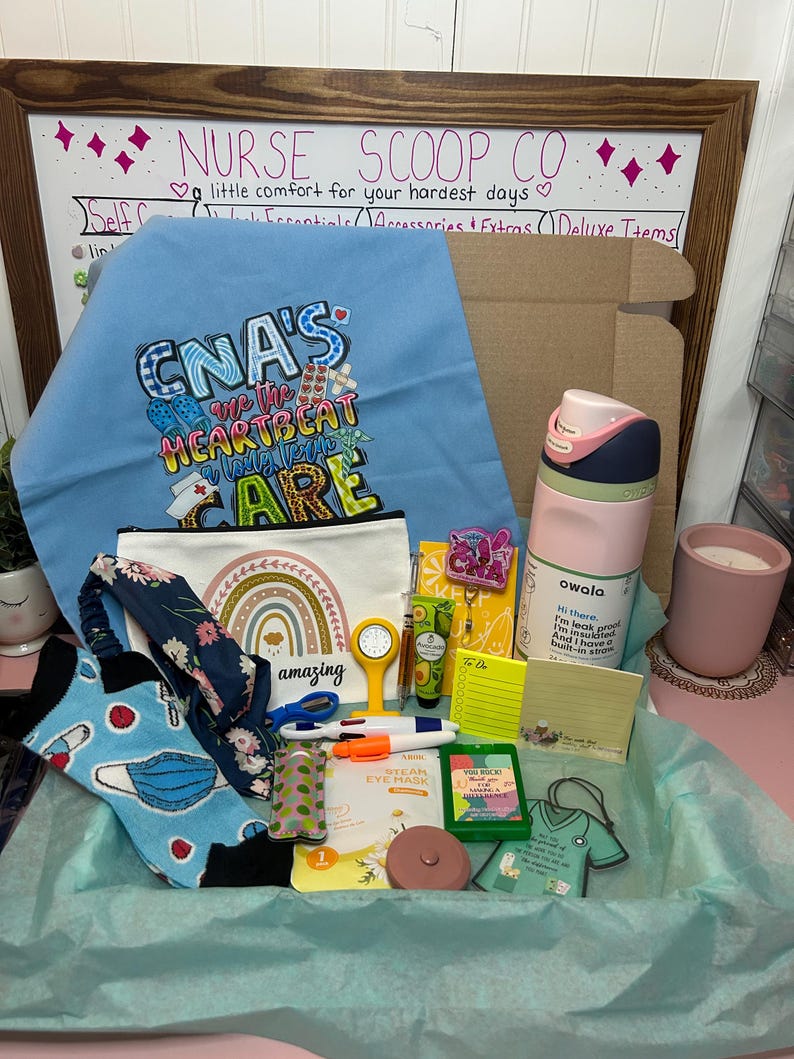 Peut inclure: Un coffret cadeau contenant un tissu bleu clair avec le texte CNA'S ARE THE HEARTBEAT OF LONG TERM CARE, une pochette blanche avec un arc-en-ciel, une gourde Owala rose et verte, des chaussettes &agrave; motifs, un bandeau floral, une horloge jaune, des stylos, des notes adh&eacute;sives, un masque pour les yeux et un ornement en forme de blouse verte.