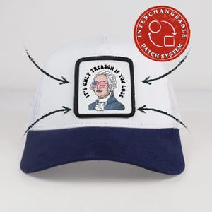 May include: A white and navy blue trucker cap featuring a square patch with an illustration of George Washington wearing American flag sunglasses. The text reads, IT'S ONLY TREASON IF YOU LOSE. A red circular logo indicates an interchangeable patch system.