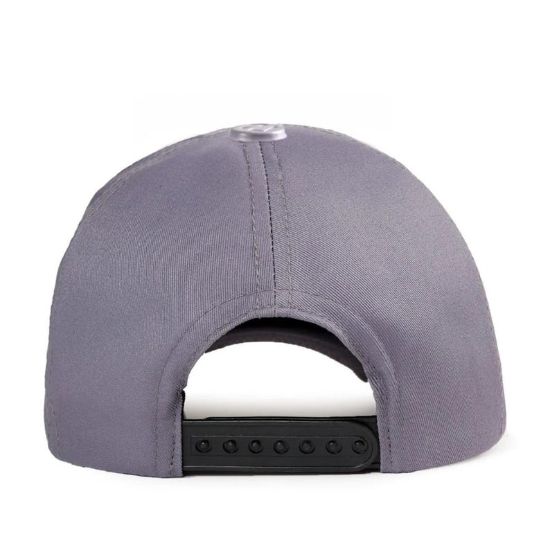 May include: A solid grey baseball cap featuring a structured crown with a central top button and a black plastic snapback closure at the rear. The cap is constructed from a smooth fabric with visible stitching along the panels and a curved opening.