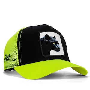 May include: A black and neon yellow trucker cap featuring a square patch on the front panel with a detailed illustration of a black panther head with piercing yellow eyes. The side panels are made of neon yellow mesh with black text branding.