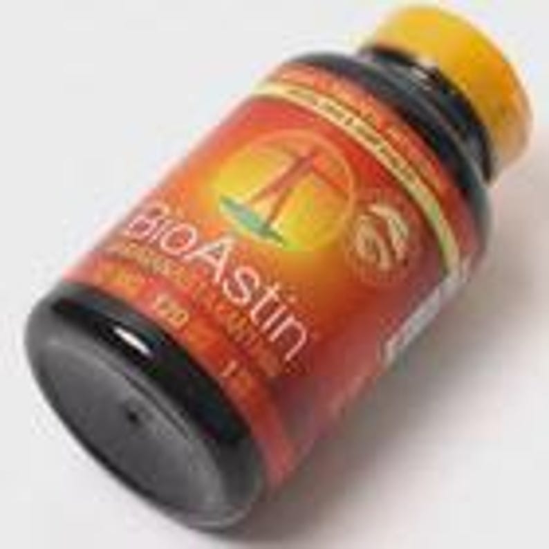 May include: A black plastic bottle with a yellow cap and a red and orange label. The label features the text "BioAstin" and an illustration of a person. The bottle contains 120 capsules.