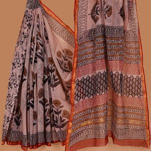 Könnte beinhalten: Ein drapiertes, hellfarbenes Saree mit floralen und geometrischen Mustern in Braun und Schwarz. Das Saree hat einen roten Rand mit goldenen Akzenten. Der Stoff wirkt leicht und fließend, geeignet für traditionelle Kleidung.
