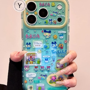 Cover per telefono Tamagotchi blu trasparente con ciondolo, cover con collage di adesivi Kawaii Y2K per iPhone 17 16 15 Pro Max, regalo per lei!