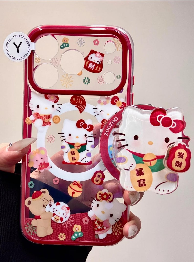 May include: Clear phone case with a red border featuring Hello Kitty characters in various poses. The case has a transparent design with decorative elements and text in Chinese characters.