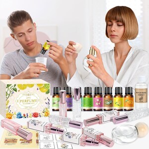 May include: A perfume making kit featuring a box labeled Perfume Making Kit, multiple small amber glass essential oil bottles with colorful labels, several clear glass spray bottles with pink caps, and a bottle of witch hazel extract.