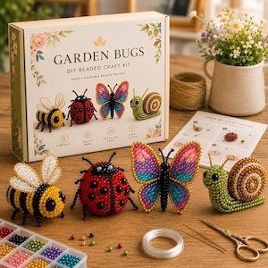 May include: A Garden Bugs DIY beaded craft kit box featuring illustrations of a bee, ladybug, butterfly, and snail. The set includes finished beaded figures of these insects, a plastic organizer with colorful beads, clear string, and needles.
