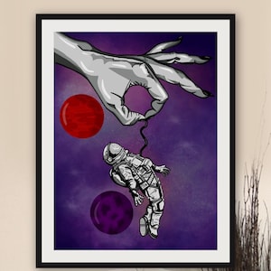 May include: A framed digital illustration featuring a large grey hand reaching down from the top to hold a small astronaut by a thin black tether. The background is a deep purple space scene with a solid red planet and a solid purple planet.
