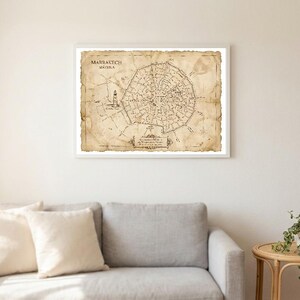 Op de afbeelding: Een ingelijste vintage-stijl kaart van Marrakech, Marokko, gedrukt op verouderd, beige papier met donkerbruine inkt. De kaart toont gedetailleerde stratenplannen, een illustratie van een bezienswaardigheid en de tekst "MARRAKECH MEDINA" linksboven.