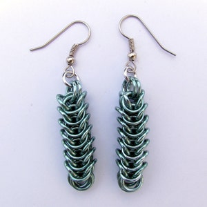 以下が含まれることがあります： ターコイズブルーのチェーンリンクデザインのシルバー製ドロップイヤリングのペア