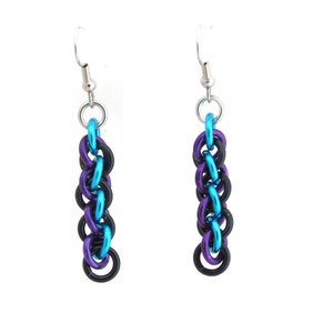 Puede incluir: Un par de pendientes colgantes con una cadena de anillos de metal negro, morado y azul.