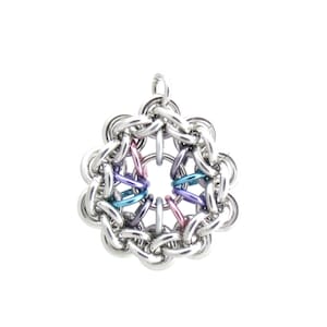 Puede incluir: Un colgante de malla de cadena plateada con un diseño circular que presenta un centro multicolor. El centro está hecho de anillos más pequeños en tonos de rosa, morado, azul y turquesa.