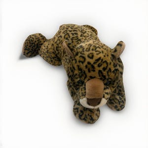 May include: A plush leopard toy in a lying position. The toy features a tan and brown spotted pattern, with a brown nose and ears. The toy is designed to resemble a leopard.