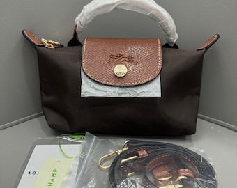 Die Longchamp Brown Mini-Umhängetasche mit verstellbarem Schultergurt ist klein und tragbar und somit das ideale Geschenk für Sie.