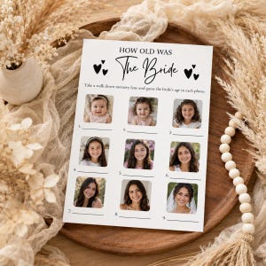 May include: A white rectangular game card titled How Old Was The Bride with black text and heart icons. The card features nine numbered photo slots for images of a person at different ages, with blank lines below each for writing answers.