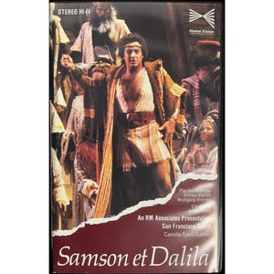 May include: A VHS tape for the opera "Samson et Dalila" featuring Placido Domingo. The cover shows a scene from the opera with actors in period costumes. The tape has the "Home Vision" logo and "STEREO HI-FI" text.