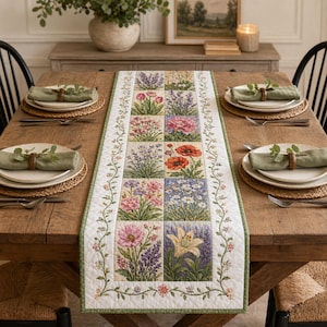 May include: A wooden dining table set for a meal, featuring a floral embroidered table runner with various flower squares. The table is set with plates, napkins, and woven placemats, creating a warm, inviting atmosphere.