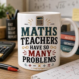 May include: A white ceramic mug featuring a graphic of a calculator at the top and the text "MATHS TEACHERS HAVE SO MANY PROBLEMS" in a mix of dark blue, black, and red lettering, with mathematical symbols including plus, minus, multiply, divide, and pi.