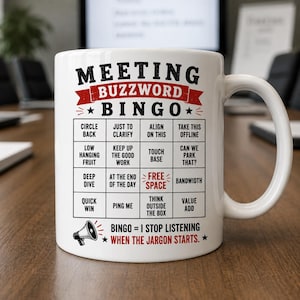 Peut inclure: Mug en céramique blanche avec l'inscription "MEETING BUZZWORD BINGO" en noir et rouge. Le mug présente une grille de bingo avec des expressions de jargon professionnel. Le texte "BINGO = I STOP LISTENING WHEN THE JARGON STARTS" est également imprimé.