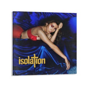 May include: A square canvas print featuring a woman in red lingerie and gold jewelry, reclining on a bed of blue satin. The word "isolation" is printed in gold lettering across the bottom of the image.
