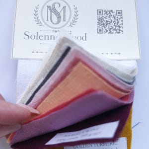 May include: A fabric swatch sample set featuring multiple colors of linen including white, grey, peach, pink, purple, burgundy, and golden turmeric. A white header card displays the Solennwood logo and a QR code. Labels indicate 100% linen, 130 g/m².