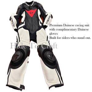 May include: Black, white, and red Dainese racing suit with matching gloves. The suit features a black torso with a red triangle logo, white legs, and black protective padding on the knees and elbows. The text "DAINESE" is visible.