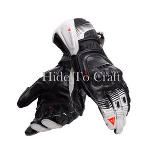 May include: Black and white motorcycle gloves with reinforced knuckles and palm. The gloves feature a combination of leather and synthetic materials, with white accents and the text "Hide To Craft".