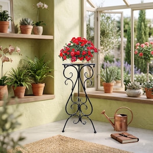 May include: A tall, black metal plant stand featuring intricate scrollwork and curved legs, topped with a round surface holding a vibrant potted rose plant with numerous bright red blossoms and deep green leaves, positioned in a sunlit room.