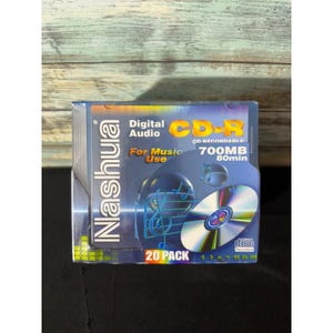 May include: A 20-pack of Nashua CD-R recordable discs for digital audio music use. The packaging is blue with a graphic of a musical treble clef and a single disc. It displays the text CD-R, 700MB, 80min, and Compact Disc Recordable logo.