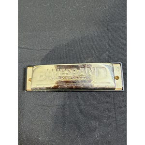 以下が含まれることがあります： BLUESBAND HOHNER INTERNATIONALの文字が刻印された金属製カバープレートを持つ、銀色のホーナー社製ブルースバンドハーモニカ。前面には1から10までの番号が振られた穴があり、右端にはCの文字が記されています。