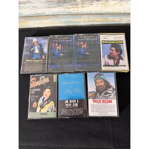 Può includere: Una collezione di musicassette vintage con artisti di musica country. Le musicassette includono Merle Haggard, Jerry Lee Lewis, Jim Reeves & Patsy Cline e Willie Nelson. Le custodie delle musicassette sono di vari colori.