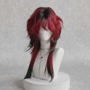 May include: A layered synthetic wig featuring a vibrant red and black color gradient. The hair is styled with a shaggy, textured cut that includes shorter, voluminous layers at the crown and longer, straight strands extending down to the shoulders.