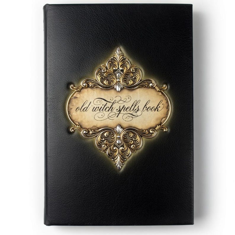 Puede incluir: Un libro negro con las palabras "old witch spells book" en escritura elegante. La portada del libro presenta un marco decorativo dorado y plateado con detalles ornamentados. La portada tiene una apariencia texturizada.