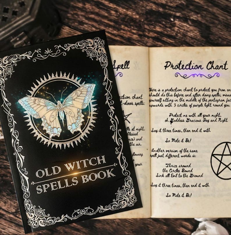 Puede incluir: Un libro abierto con una cubierta negra titulado "OLD WITCH SPELLS BOOK" con una ilustraci&oacute;n de mariposa. Las p&aacute;ginas abiertas muestran texto manuscrito y un pentagrama. El libro tiene un borde decorativo.