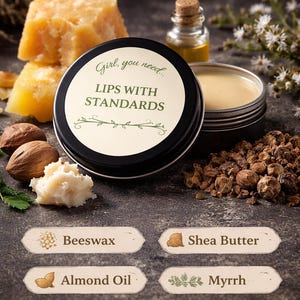 May include: A close-up image showcases a lip balm tin with the text "LIPS WITH STANDARDS." Ingredients like beeswax, shea butter, almond oil, myrrh, and manuka & vetiver are also displayed. The image has a natural, earthy aesthetic.