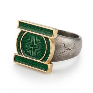 May include: A ring featuring a gold-toned rectangular frame with a central circular motif, both filled with textured green enamel. The band is made of a dark, weathered metallic material with a visible crack-like texture on the outer surface.