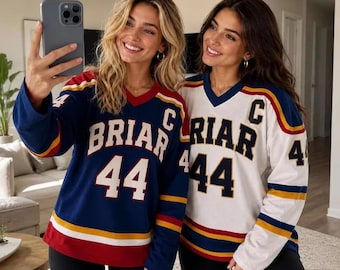 May include: Two long-sleeve V-neck jerseys featuring the text BRIAR and the number 44 on the front. One jersey is navy blue with white and yellow accents, while the other is white with navy blue and yellow accents. Both have a letter C on the chest.
