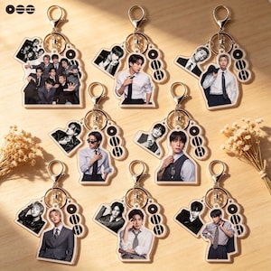 May include: A collection of eight acrylic keychains featuring photographic prints of individuals in formal attire, including white shirts, ties, and suits. Each keychain includes a gold-toned metal lobster clasp and a small circular charm with the text OOO.