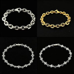 Pode incluir: Quatro pulseiras em fundo preto. Duas são prateadas, uma com design de elos e outra com padrão floral. As outras duas são douradas, uma com design de elos e outra com padrão floral.