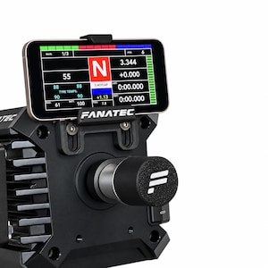 May include: A black Fanatec racing wheel base featuring a mounted smartphone display showing telemetry data including gear, lap times, and tyre temperatures. The device has a central cylindrical knob with a white logo and a power switch on the side.
