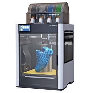 Peut inclure: Une imprimante 3D avec une chaussure bleue à l'intérieur. L'imprimante est grise et blanche avec une porte transparente. Au-dessus de l'imprimante se trouvent des bobines de filament de différentes couleurs. Un petit écran est à l'avant.