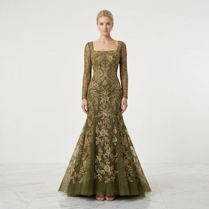 May include: Olive green formal gown with a square neckline and long sleeves. The dress features intricate gold floral embroidery throughout the bodice and skirt, which flares out at the bottom. The gown is floor-length and appears to be made of a sheer fabric.