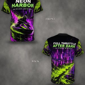 Puede incluir: Una camiseta negra de manga corta con un estampado gráfico en verde neón y morado. El frente muestra a un conductor de moto de agua con el texto NEON HARBOR RIDE THE LIGHTS. OWN THE NIGHT. La espalda muestra un horizonte con FULL THROTTLE AFTER DARK.
